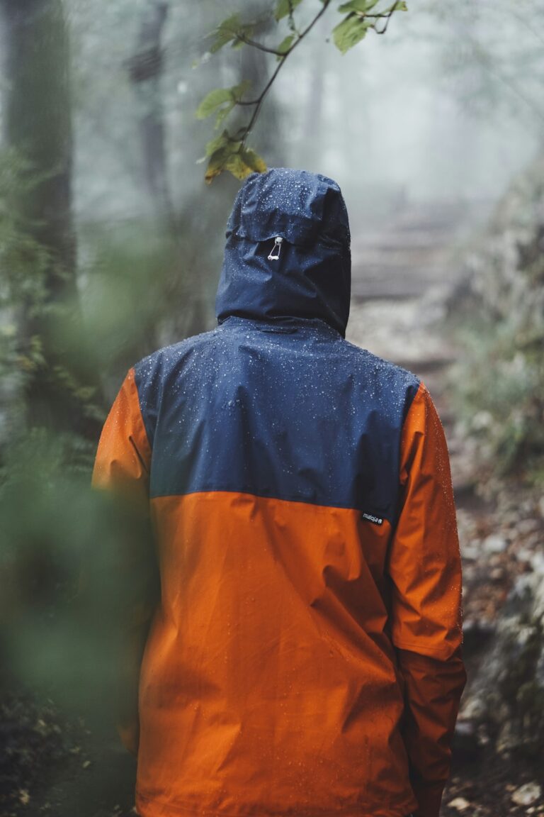 Camping gear in Nairobi – hiker wearing an orange and blue hooded raincoat